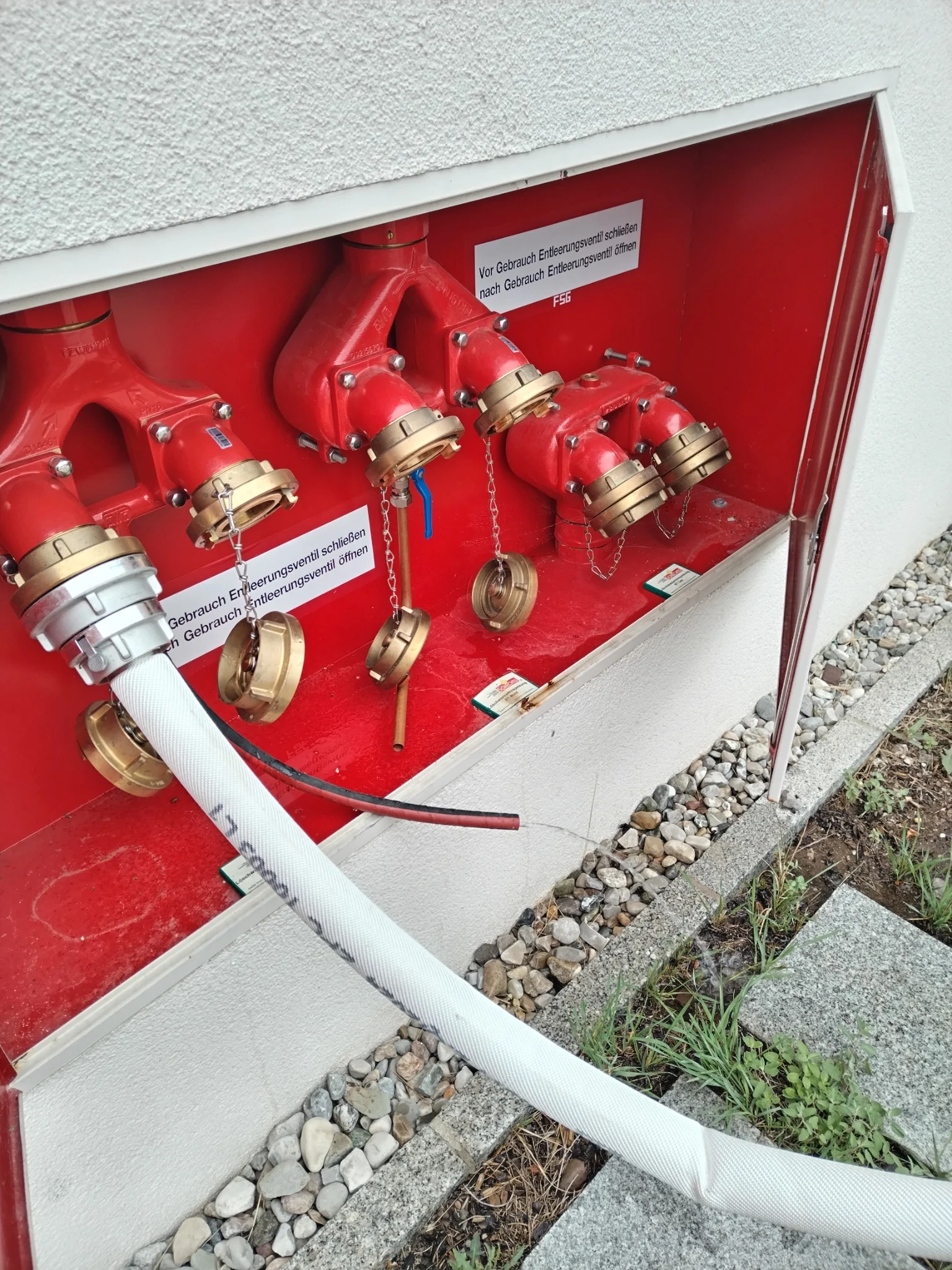 Löschwasseranschlüsse und Schläuche in einem Feuerlöschschrank
